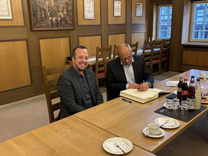 Bürgermeister Timo Riedemann (links) und Innenminister Prof. Dr. Roman Poseck bei der feierlichen Eintragung ins Goldene Buch der Stadt Melsungen im Rahmen der Übergabe des Förderbescheids „Sicherheit bei Veranstaltungen“.